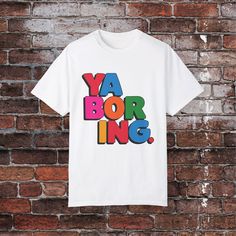 Add a dose of humor to your wardrobe with this 'Ya Boring' t-shirt! Featuring bold, eye-catching typography on a crisp white background, this shirt is perfect for those who love to make a statement in a fun and cheeky way. It's sure to spark conversations and perhaps even a few chuckles. Product features - Available in sizes S to 3XL - Double-needle stitching for durability - Garment-dyed fabric for soft texture - Made with 100% US cotton for comfort - Classic crew neckline for versatile styling Pop Culture Letter Print Shirt, Bold Typography Design, Bold Typography, Statement Tees, Funny Quote, Dyed Fabric, Soft Texture, Soft Textures, Typography Design