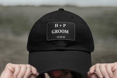 a person wearing a black hat with the word h + p groom on it's back