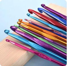 there are many different colored toothbrushes on the wooden holder, all lined up