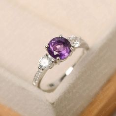 This ring features a 7*7 mm round cut amethyst. Customization is available. It is made by hand, and it will take about 7 days to finish the ring after your payment is completed. Main stone: 7*7 mm round cut Main stone weight:1.25 ct Metal type: sterling silver /14k gold Accent stone: cz Customization is available, just fee free to contact me, it is free to engrave inside the ring, it is free, you can leave a ntoe with your order, but it will be great no more than 15 letter. Any question, just le Luo Jewelry, Amethyst Engagement Rings, February Birthstone Ring, Amethyst Ring Engagement, Silver Engagement Ring, Purple Band, February Birthstone, February Birth Stone, Girly Jewelry