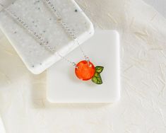 This tiny orange with little green leaves hangs on a fine silver chain. The pendant is entirely handmade from clear solid polystyrene coated in resin. The orange measures about 2 cm wide (including leaves) and the chain length adjusts between 16-18 inches. The necklace is lightweight, minimal, and comfortable. Everything in my shop is handmade by me, and I draw each tiny piece by hand, so expect the subtle differences of hand-drawing. Find matching earrings here: https://www.etsy.com/listing/501 Fruit Necklace, Necklace Orange, Kawaii Jewelry, Orange Fruit, Milwaukee Wi, Hand Drawing, Fine Silver, Matching Earrings, Chain Lengths