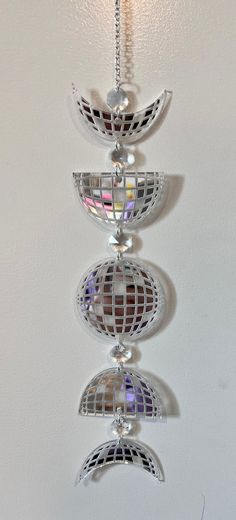 a metal object hanging from the ceiling with mirrors on it's sides and lights in the middle