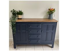 a blue dresser with two potted plants on top