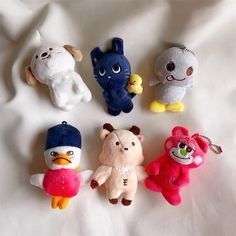 several stuffed animals are arranged on a white sheet