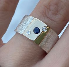 Natural Sapphire (3mm) and diamond (2mm - 0.03 carats each) sterling Silver and 14k Gold Ring, Wide Band Silver ring Wide: 10mm Thickness: 1,5mm Dark Blue natural sapphire : 3mm (0.10ct) Natural diamond: 2mm each ( 0.03carats) This natural Sapphire and diamonds Ring in Solid 925 Sterling Silver and 14k Gold is absolutely beautiful. Handcrafted Ring. Ring will be packed in a beautiful gift box and bag with Pearls Box logo ready for giving! PLEASE NOTE- shipping time does not include making time. Wide Rings With Stones, Wide Band Engagement Ring Unique, Wide Band Diamond Rings, Wide Band Engagement Ring, Thick Gold Ring, Wide Gold Ring, Silver Gold Jewelry, Metalsmithing Jewelry, Wide Band Ring