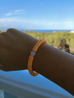 pulsera de cuentas con una cara sonriente con cuentas naranjas y cuentas amarillas. Playful Orange Beaded Bracelets With Letter Beads, Playful Yellow Friendship Bracelets With Letter Beads, Orange Beaded Friendship Bracelets With Letter Beads, Orange Letter Beads Friendship Bracelets, Fun Yellow Beaded Bracelets With Colorful Beads, Yellow Playful Beaded Bracelets With Round Beads, Cute Orange Beaded Bracelets, Fun Yellow Handmade Beaded Bracelets, Playful Orange Bracelets With Colorful Beads