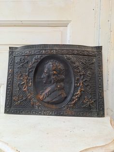 an old bronze plaque with a man's face on it in front of a door