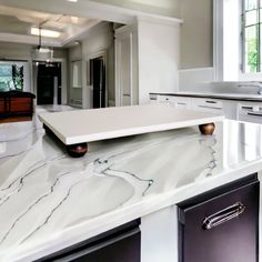 a kitchen with marble counter tops and white cabinets