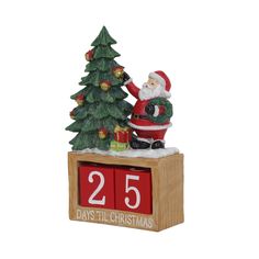 a wooden box with a christmas tree and santa clause on it, next to a calendar