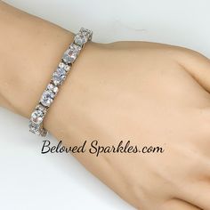 Lily Oval Cubic Zirconia 28ct Silver Tennis Bracelet. This statement tennis style is created with oval and round cubic zirconia. This luxe piece paired with glistening accompaniments is perfected compliment for the event attire. Only the best quality cubic zirconia is use on our fine jewelry collection. Our genuine rhodium finish is achieved using an electroplating process that coats the item with heavy layers of rhodium, a close cousin to platinum, which gives our jewelry a platinum luster. Thi Oval Cubic Zirconia Tennis Bracelet For Wedding, Wedding Oval Cubic Zirconia Tennis Bracelet, White Crystal Tennis Bracelet For Party, White Bling Bracelets For Formal Occasions, Formal White Bling Bracelets, Oval Hand Set Tennis Bracelet For Wedding, Silver Crystal Tennis Bracelet For Wedding, Wedding Crystal Tennis Bracelet Sparkling, Sparkling Crystal Tennis Bracelet For Weddings