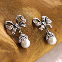 "These earrings feature our exquisite dimensional bows, set with 75 glimmering Swarovski crystals. 8mm pearls. Just the right size - demure and graceful. 1\" long by 0.75\" wide. Choice of Silver or Bronze finish. Post back. Designed and made in our Los Angeles studio. Matching piece: https://www.etsy.com/listing/215392898/bow-necklace-pearl-bow-silver-bow?ref=shop_home_active_1&ga_search_query=bow Contact us for bulk pricing and wholesale information." White Bow Earrings For Wedding, Classic Bow Earrings For Anniversary, Silver Bow Earrings For Anniversary, Classic Silver Jewelry With Bow Detail, Classic Silver Jewelry With Bow, White Bow Jewelry For Formal Occasions, Elegant Bow Earrings For Formal Occasions, White Bow Jewelry For Evening, Elegant Formal Earrings With Bow