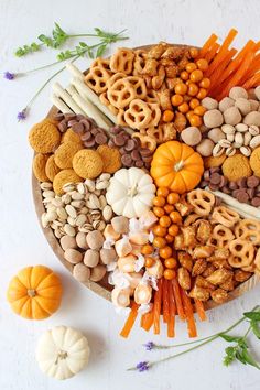 a platter filled with lots of different types of snacks and nuts on top of each other