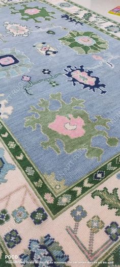 a blue and green rug with flowers on it