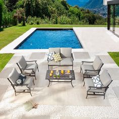 an outdoor patio with chairs and tables next to a swimming pool in the middle of it