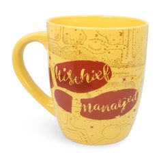 a yellow coffee mug with red lettering on it