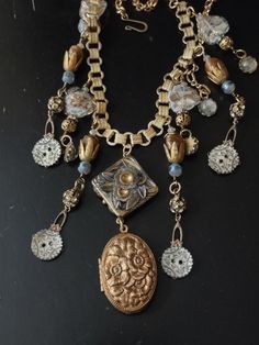 "A vintage Victorian-inspired assemblage in blues and golds. The central pendant is a Czech glass large button mounted on brass. It looks Art Deco, but I believe it is a vintage replica. It holds a vintage brass locket with a repousse floral motif. Inside I've added a digital print of a renaissance painting under resin \"glass\". Accompanying pendants are vintage Venetian glass with blue foil, vintage prong set rhinestone brass beads, filigree brass beads, vintage brass caps, reproduction carved Vintage Handmade Metal Medallion Necklace, Handmade Vintage Metal Medallion Necklace, Unique Vintage Style Medallion Necklace, Unique Medallion Necklace From Vintage Collection, Vintage Metal Medallion Necklace, Antique Necklace With Vintage Charm, Vintage Gold Medallion Pendant Necklace, Vintage Gold Medallion Necklace With Round Pendant, Bronze Medallion Necklace For Vintage Collection