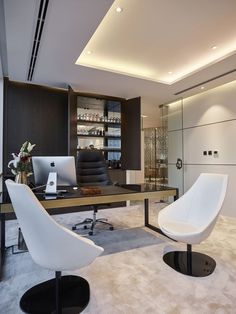 two white chairs sitting in front of a computer desk