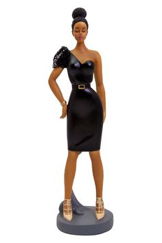 a figurine of a woman in a black dress with gold shoes and heels