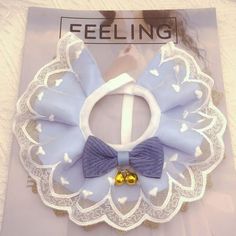 a blue and white hair bow on top of a piece of paper with a gold bead in the middle