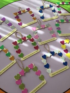 a table topped with lots of different colored paper hearts and nametags on them