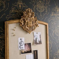 an ornate gold frame with pictures and other items hanging on the wall next to it