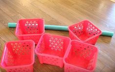 six pink plastic baskets sitting on the floor