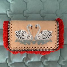 Stunning Stella Bag, Collector Piece. New, Never Been Used With Original Dust Bag. Super Soft. Can Be Used As A Clutch Or A Crossbody Bag. Authentic Stella Mccartney 'Falabella' Swan Fringe Clutch / Crossbody Bag Size Info 8 ½"W X 5"H X 2 ½"D 21 ½" Crossbody Strap Drop Details: Swan Embroidery Rose Colored Exterior With Bright Red Fringe Lining The Front Flap Magnetic-Snap Closure Stella Logo On Interior Pocket Gunmetal Hardware/Strap Vegan Synthetic Leather Swan Embroidery, Stella Bag, Stella Logo, Embroidery Rose, Fringe Clutch, Red Fringe, Stella Mccartney Falabella, Stella Mccartney Bag, Gunmetal Hardware