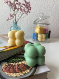 there is a book and some flowers on top of the table next to each other