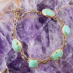 This elegant bracelet boasts genuine bronze and turquoise, with ornate casting details that create a timeless, luxurious look. You'll love the 7.5" length and toggle closure, making it perfect for your special occasions. Experience the beauty of this gorgeous link bracelet! 💍👑 Elegant Bronze Jewelry With Patina, Adjustable Elegant Jewelry With Patina Detail, Elegant Adjustable Jewelry With Patina, Elegant Turquoise Bracelets With Patina, Elegant Turquoise Bracelet With Patina, Elegant Patina Bracelets As Gift, Turquoise Patina Bracelet Jewelry, Turquoise Patina Bracelet, Bronze Ring