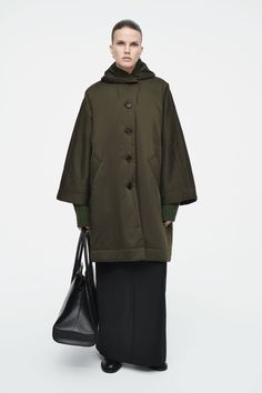 The womenswear team reimagine the padded coat in a distinctive silhouette for Autumn Winter 2024. This khaki piece is designed with a cocooning shawl collar, ultra lightweight filling and an oversized shape, with pockets on the front to keep your hands warm. Oversized fitButton closureREFIBRA™ is a trademark of Lenzing AG. TENCEL™ Lyocell is a recycled fiber made from post-production cotton scraps and unused clothing mixed with natural wood pulp  Shell: 66% TENCEL™ REFIBRA™ Lyocell, 17% Recycled Cozy Oversized Wool Outerwear, Oversized Wool Shawl Outerwear, Oversized Single-breasted Wool Coat, Oversized Solid Single-breasted Wool Coat, Cos Coat Wool, Padded Coat, Green Coat, Shawl Collar, Hand Warmers