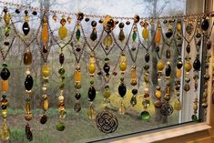 a window with many different colored beads hanging from it's glass pane in front of the window