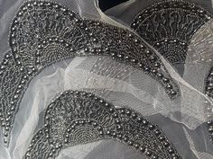 THE Queen applique makes the perfect start to a black tie gown or Greek Goddess dress! Beautiful silver beads are hand sewn onto a white mesh. Sold by the piece. Embellished Tulle Fabric For Evening, Elegant Embellished Tulle Fabric For Party, Elegant Embellished Fitted Tulle Fabric, Beaded Fitted Tulle Fabric For Party, Elegant Fitted Beaded Tulle Fabric, Elegant Tulle Fabric With Pearl Embroidery For Party, Elegant Pearl Embroidered Tulle Fabric For Party, Elegant Embellished Sequin Tulle Fabric, White Embellished Tulle Fabric For Party