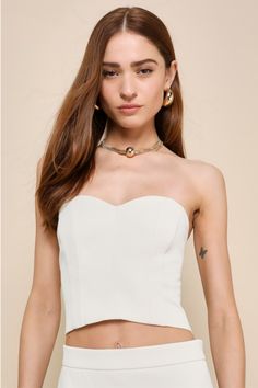 You'll be the best-dressed babe at the soiree in the Lulus Chic Invite Cream Strapless Bustier Crop Top! Lightweight woven twill shapes this chic top with a strapless, sweetheart neckline (with hidden no-slip strips) and a cropped bodice with a bustier-style silhouette and stylish seam details. Exposed zipper at back. Pair with the matching skirt for a complete look! Fit: This garment fits true to size. Length: Size medium measures 10.5" from top to bottom. Bust: Great for any cup size. Waist: F Chic Summer Tube Top With Built-in Bra, Chic Tops With Built-in Bra And Fitted Bodice, Fitted Crop Top With Built-in Bra For Party, Feminine Fitted Tube Top With Built-in Bra, Elegant Summer Tube Top With Built-in Bra, Strapless Flirty Corset With Built-in Bra, Flirty Strapless Corset With Built-in Bra, Glamorous Strapless Tube Top With Built-in Bra, Chic Fitted Bodice Tube Top For Date Night