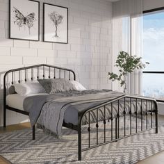 a bedroom with white brick walls and black iron bedspread on top of a rug