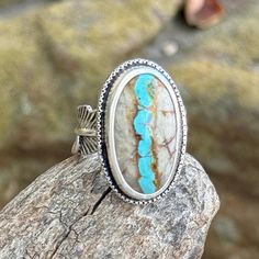 Natural Royston Ribbon Turquoise Sterling silver statement ring Royston Ribbon Turquoise has pulled at my heart strings once again. Usually turquoise is cut so that the face of the stone is all turquoise. For Royston Ribbon, they cut a cross-section, so that you can see the vein of turquoise running through the rock. It mesmerizes me.  This is a glorious piece of natural, untreated ribbon turquoise from the Royston Mine in Nevada. A very striking pattern of turquoise and natural light brown matrix. I used 999 fine silver around the stones, twisted sterling wire, and a feather band. This is a really solid piece that's going to last for generations. The ring measures at a size 8 and is marked .925.  I do not offer resizing for rings. The reason for this is that in order to resize a ring I mu Royston Turquoise Ring, Untreated Bohemian Turquoise Ring, Rustic Sterling Silver Turquoise Ring Gift, Unique Turquoise Inlay Ring, Artisan Turquoise Gemstone Ring, Unique Adjustable Turquoise Ring With Natural Stones, Bohemian Turquoise Ring With Natural Chrysocolla, Bohemian Turquoise Ring With Chrysocolla, Bohemian Turquoise Chrysocolla Ring With Natural Stones