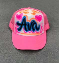 Airbrushed SnapBack Trucker Hat with your choice of lettering and color scheme.  Hats are made with a white polyester foam front and colored mesh back with a one size fits most snap enclosure. Spray Paint Trucker Hats, Airbrush Hats Design, Customizable Multicolor Trucker Hat, Personalized Adjustable White Trucker Hat, Personalized White Adjustable Trucker Hat, Personalized Pink Snapback Trucker Hat, Customizable Pink Snapback Trucker Hat, Personalized Fun Snapback Baseball Cap, Customizable Pink Snapback Hat With Curved Brim