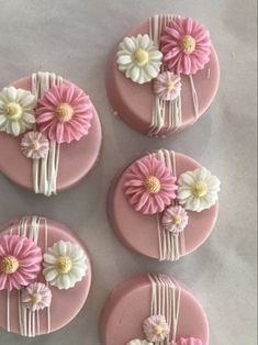 four pink and white decorated cookies with flowers on the top one is for someone's birthday