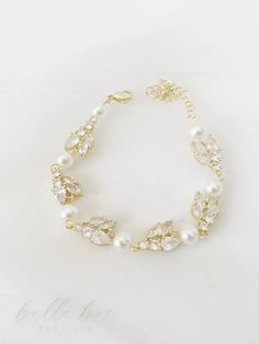 a bracelet with pearls and leaves on it