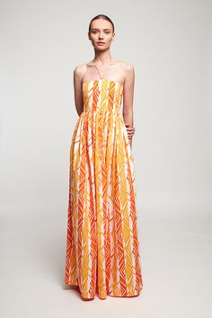 DESCRIPTION This floaty dress is made from lightweight cotton printed with a Spanish-inspired arrangement of golden yellow and orange hues. Cut for a close fit, it has a flattering halterneck and softly pleated skirt for ease of movement. Temper the maxi hem with sandals or heels. * Prints and colours may vary slightly Orange Strapless Maxi Dress For Summer, Yellow Strapless Maxi Dress For Vacation, Summer Strapless Orange Maxi Dress, Orange Strapless Vacation Dress, Orange Strapless Sundress, Orange Halter Neck Dress For Summer, Chic Orange Halter Dress For Summer, Orange Summer Halter Neck Dress, Yellow Halter Neck Dress For Summer