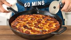 the pizza is being cooked in a skillet on top of a wooden table with instructions to make it