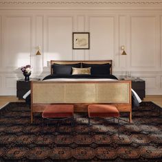 a large bed sitting on top of a wooden floor next to a chair and ottoman