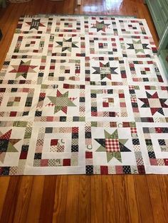 a quilt is laying on the floor in front of some cupboards and a table