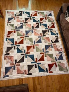 a living room with a couch and a quilt on the floor in front of it