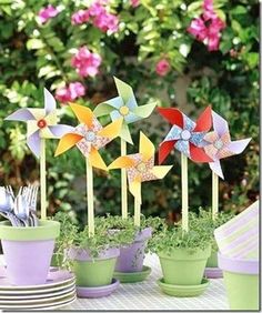 a table topped with potted plants and small pinwheels on top of each other