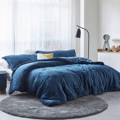 a bed with blue comforter and pillows in a room