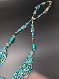 This is a listing for one 41" turquoise, silver, clear and white necklace.  This necklace has many different sizes and shaped beads.  It is quite elegant.  The closure is magnetic, but also has two magnets so you can bring the necklace together for a different look. The bottom is made of 9 strands of seed beads in beautiful, vibrant turquoise and clear beads. #158 Turquoise Faceted Beads Necklaces For Party, Party Turquoise Beaded Necklaces With Faceted Beads, Turquoise Necklace With Large Beads For Party, Party Turquoise Faceted Beaded Necklaces, Turquoise Necklaces With Round Beads For Party, Turquoise Round Beads Necklace For Party, Turquoise Polished Beads Necklace For Party, Turquoise Glass Necklaces With Large Beads, Turquoise Costume Jewelry Necklace For Party