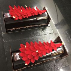 two chocolate bars decorated with red flowers on top of each other, sitting on a table