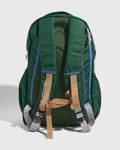 a green backpack sitting on top of a white floor