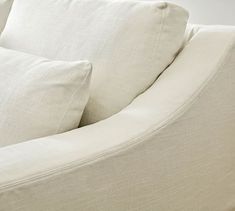 a close up view of the back end of a white couch with pillows on it