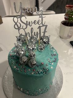 there is a blue cake with silver decorations on the top that says yummy sweet stuff